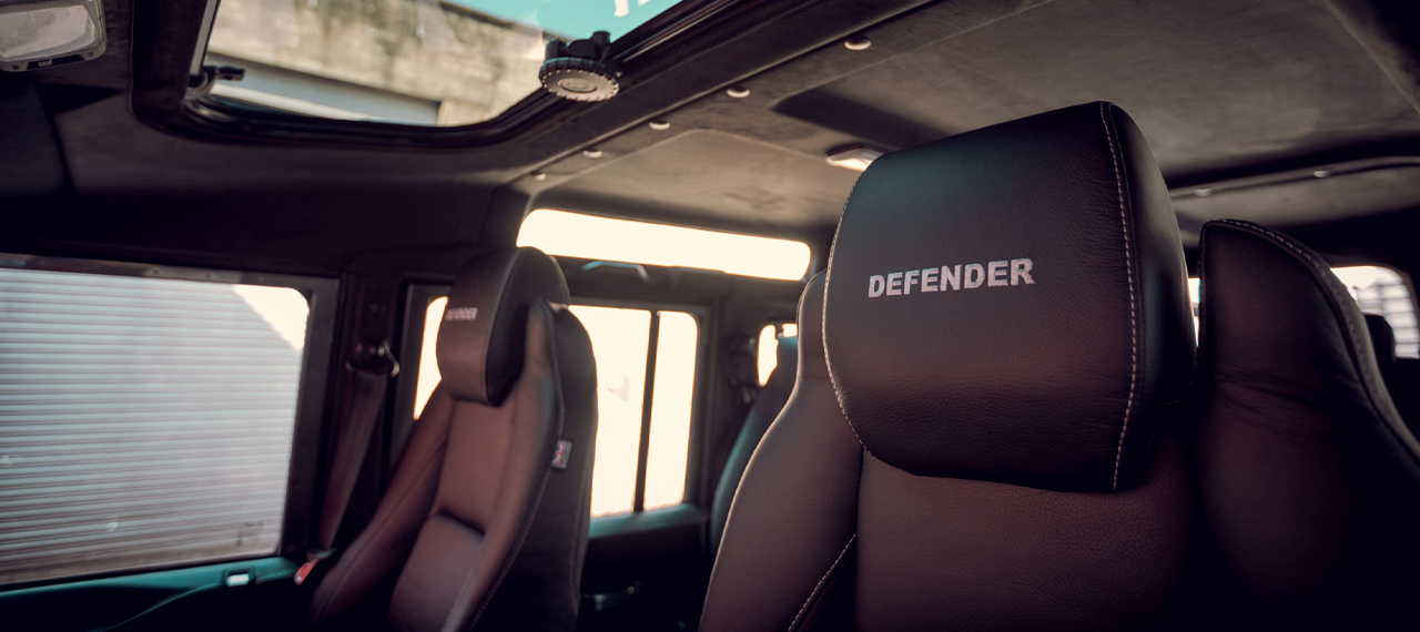 Inside view of Defender with black leather and embroidered headrests.