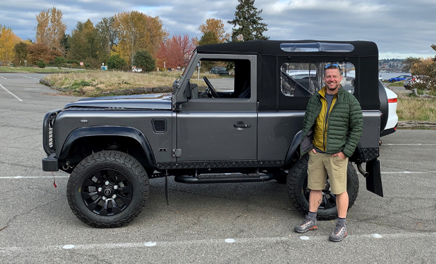 Man standing next to a Defender 90