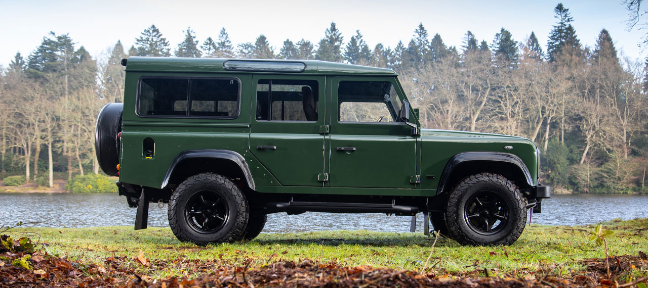 Side view of Coniston Green Defender 110 with view of lake behind