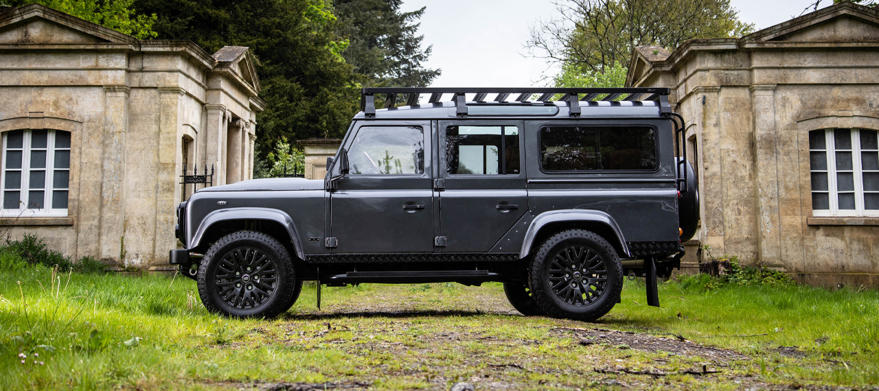 Side view of Bonatti Grey Defender 110 in front of ruins