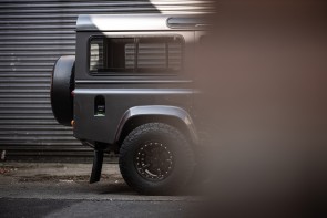 Obscured view of back end of a Defender packed in an alleyway