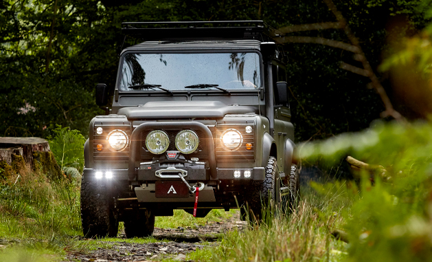 Arkonik Defender in the forest with lights on.