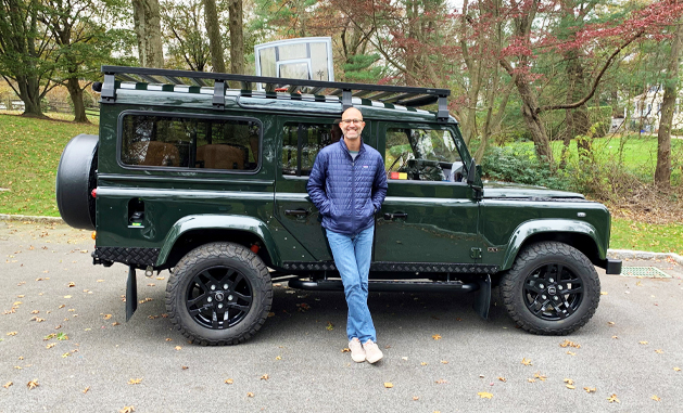 Man stood next to a green Defender 110.