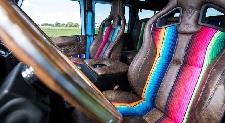 Mexican blanket and brown leather sports seats inside Defender 110.