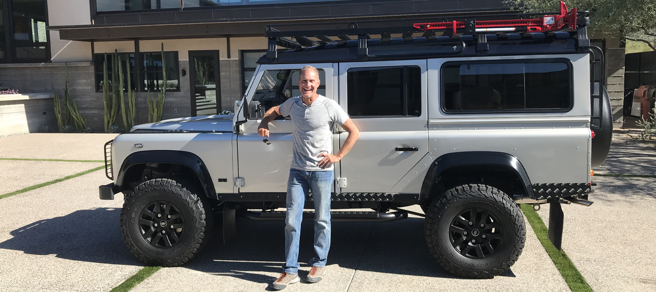 Happy Arkonik standing with his new Defender 110