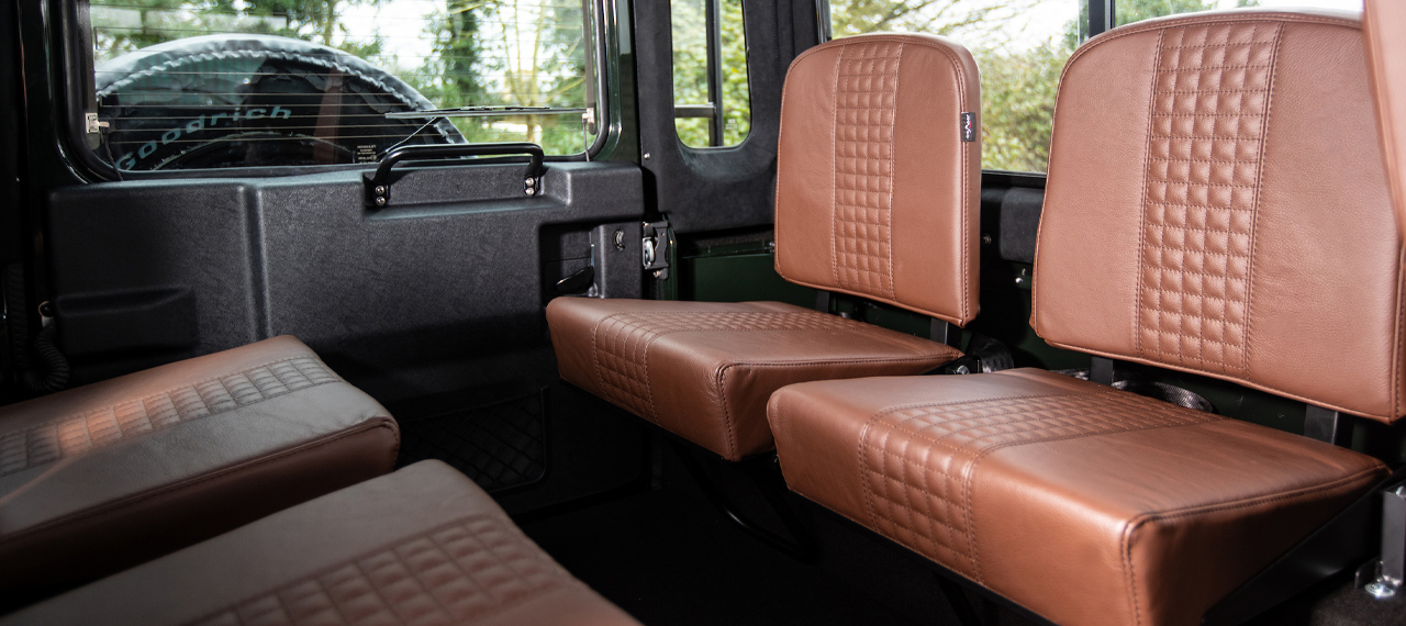 View of Defender load area with tip-up seats in brown leather