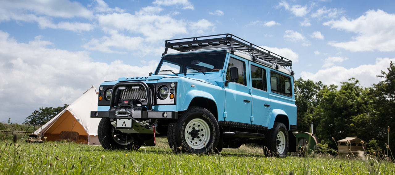 Sky Blue Defender 110 with Chawton White roof and roof rack.