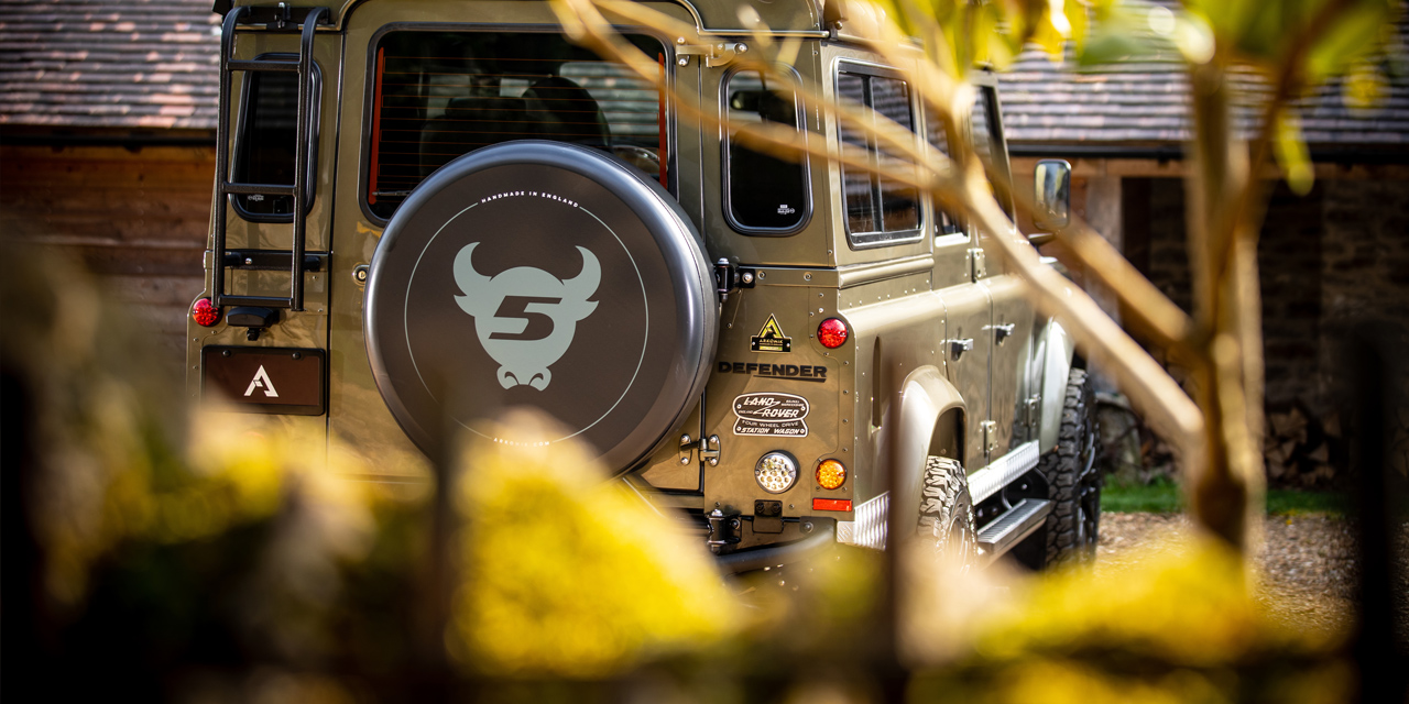 Rear view of Land Rover Defender 110 with custom wheel cover