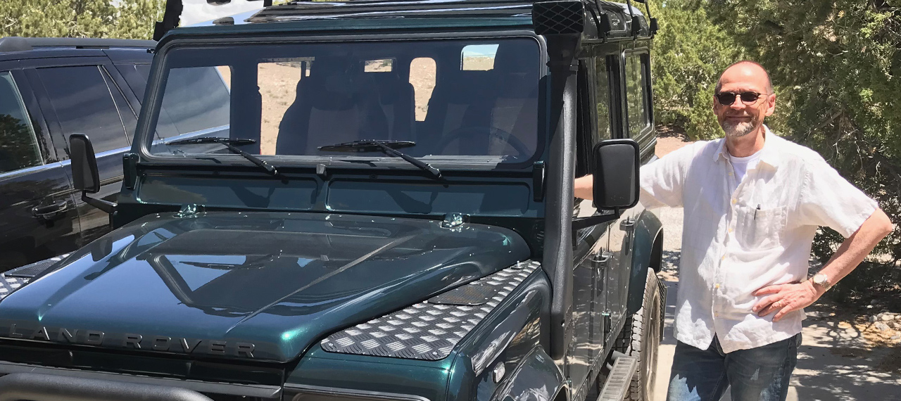 Owner of Navajo D110 standing next to his new Defender