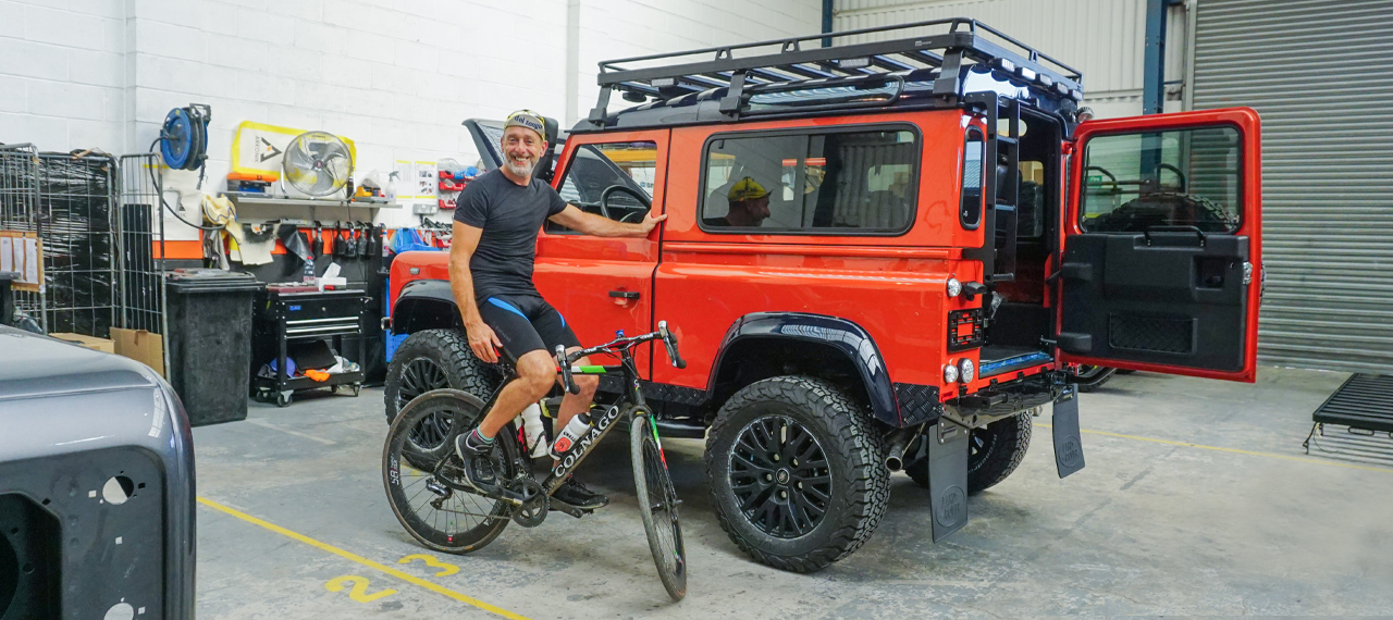 Andy Hayes on his bike next to an Arkonik Defender