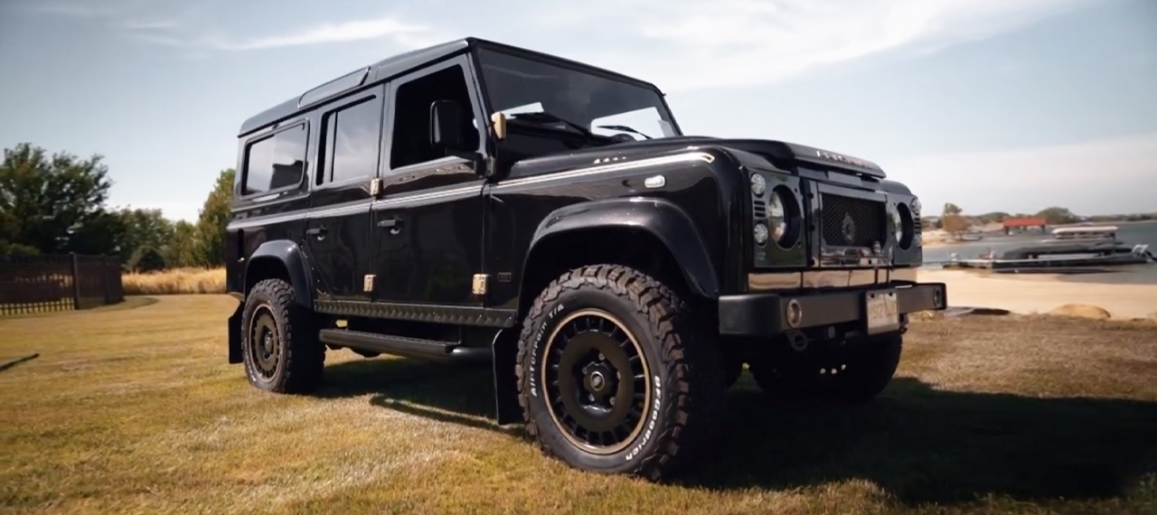 Santorini Black Defender parked by a lake